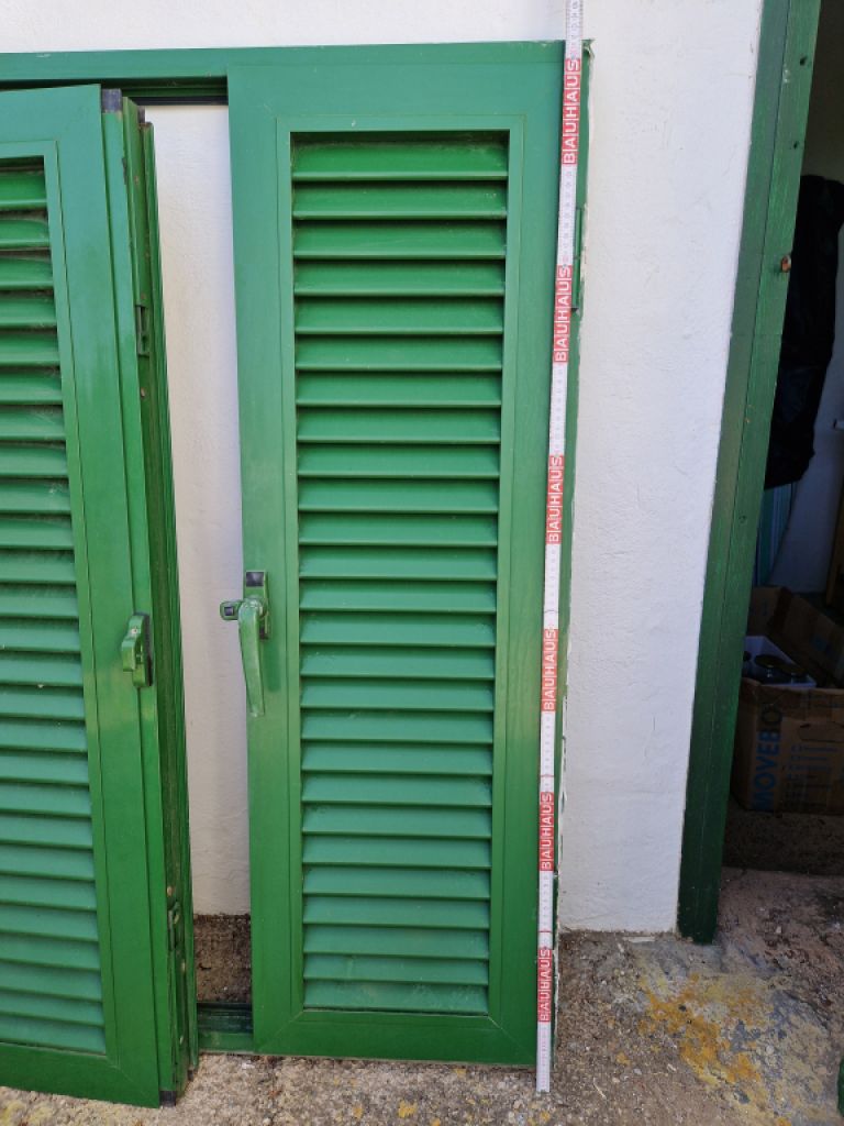 Persianas verdes (contraventanas) de aluminio.