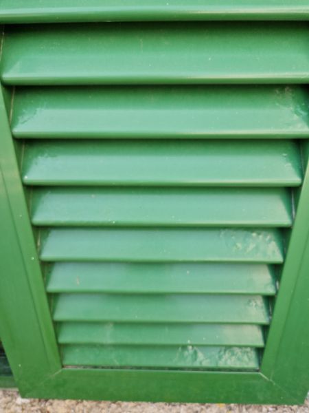 Persianas verdes (contraventanas) de aluminio.