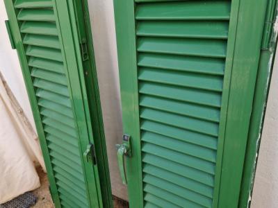 Persianas verdes (contraventanas) de aluminio.