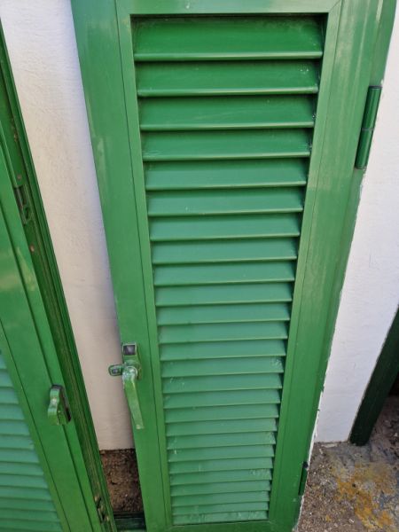 Persianas verdes (contraventanas) de aluminio.