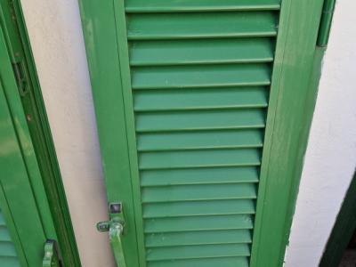 Persianas verdes (contraventanas) de aluminio.