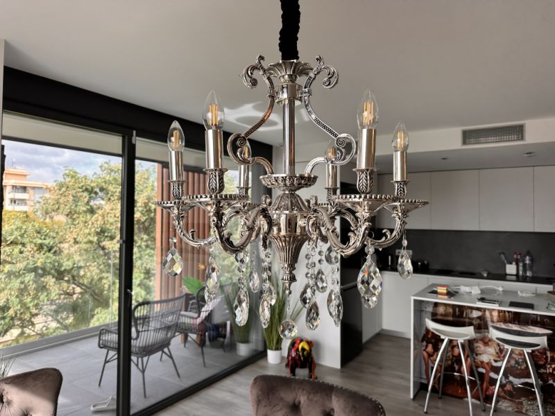 Vendo mi elegante candelabro de diseño clásico con colgantes de cristal relucientes.